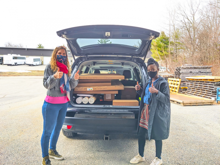 women smiling behind an open hatchback